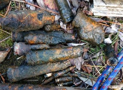 German children fish WW2 ammunition from pond with magnet