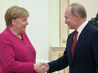 Putin gives Merkel flower bouquet, her mobile phone's ringtone heard at that moment