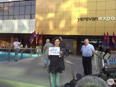 Activists hold “SaveAmulsar” posters during Pashinyan's visit to exhibition