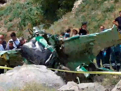 In Armenia, rescuers try to extract the bodies of two victims from a crashed airplane