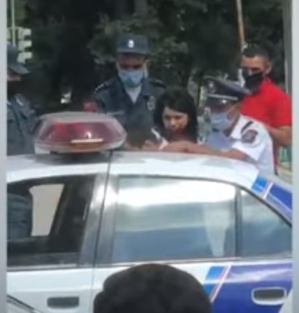 Ոստիկանները երիտասարդ կնոջը քաշքելով նստեցնում են մեքենա ու բերման ենթարկում